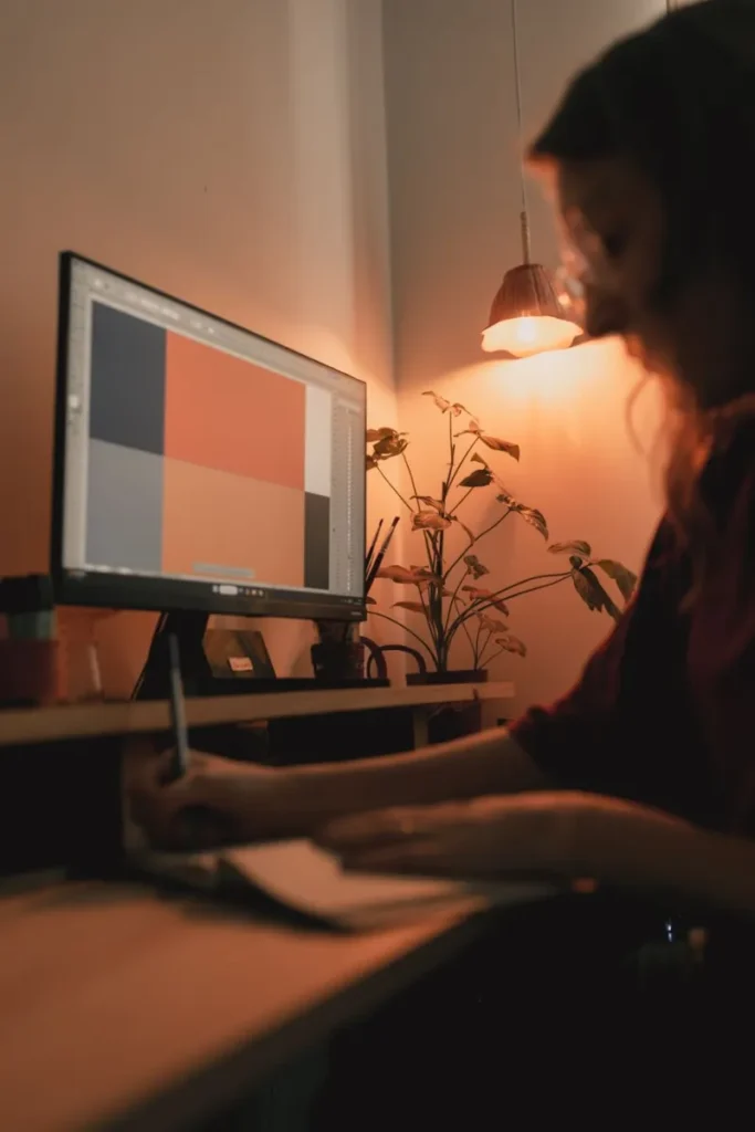 Designer reviewing a brand colour palette and website layout at her desk